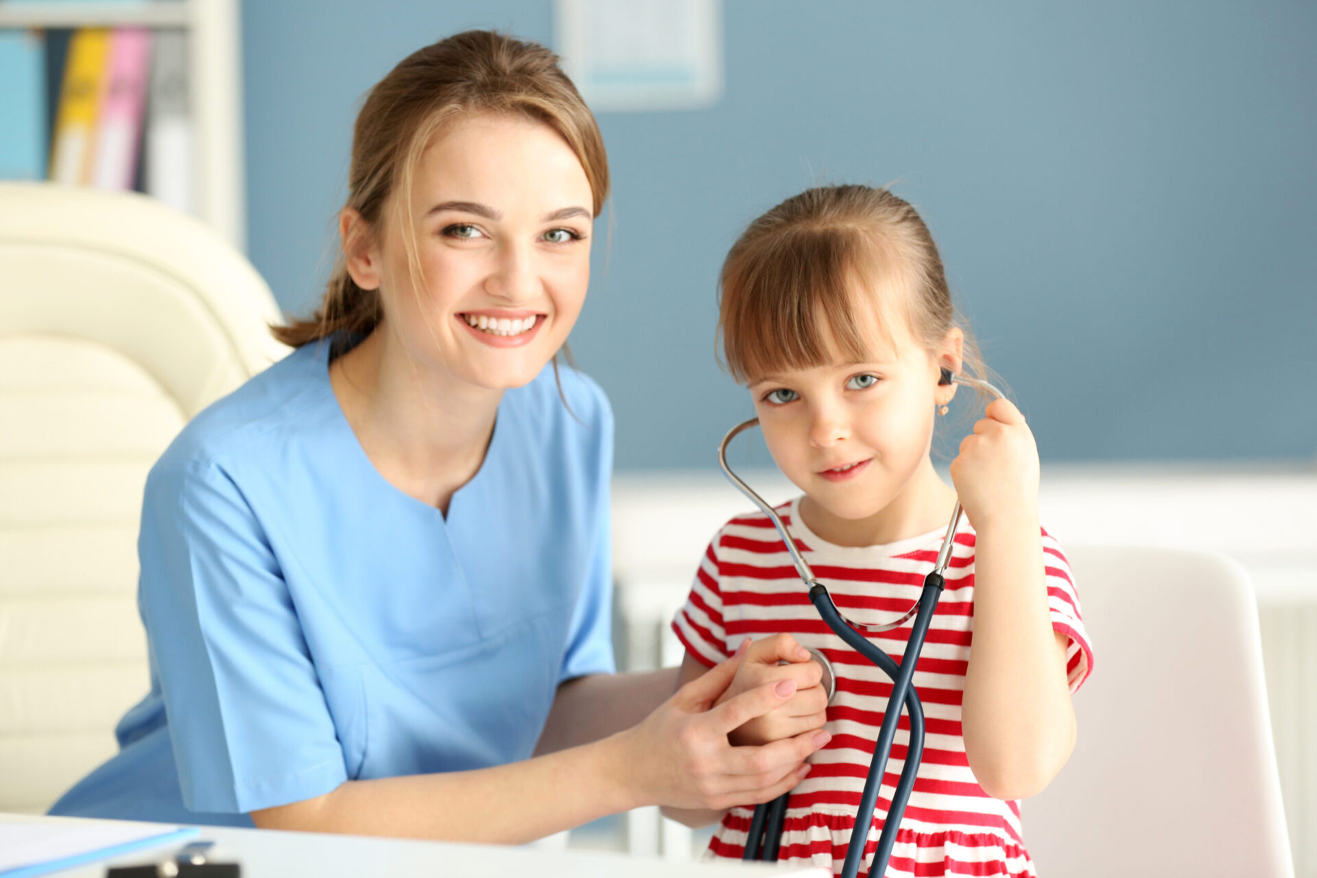 Doctor examining girl with stethoscope in the office